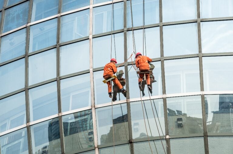 Fensterputzer an der Glasfassade zur Gebäudereinigung